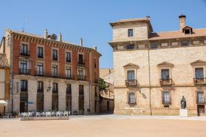 un grupo de edificios y una estatua en un patio en Tirso de Molina en Almazán