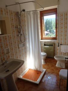 a bathroom with a shower and a sink and a toilet at Hotel Caldora in Rocca di Mezzo