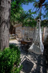 a hammock hanging from a tree next to a table at Villa Mimi' in Nardò