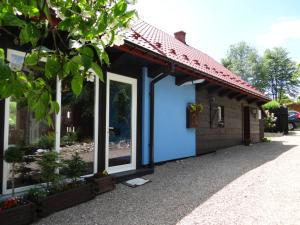 a house with a blue door on the side of it at Agroturystyka Dyrdówka in Byszyce