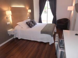 a hotel room with a bed and a window at Hotel Llorca in Platja de l’Almadrava