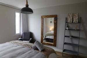 a bedroom with a bed and a mirror and a chair at Swakopmund Pearl in Swakopmund