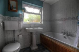 a bathroom with a tub and a sink and a toilet at Bryn Ffynnon Holiday Cottage Llanrwst in Llanrwst
