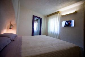 a bedroom with a bed and a television on the wall at Villa Mimi' in Nardò