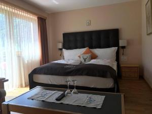 a bedroom with a large bed and a table with glasses on it at Hotel Pizzeria Selva in Zernez