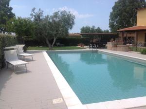 a swimming pool with two chairs and a water slide at Villa Trieste in Albinia