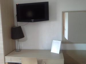a room with a tv on a wall with a table at Villa Del Mar in Bari
