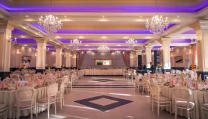 einen Bankettsaal mit Tischen, Stühlen und Kronleuchtern in der Unterkunft Hotel Melody in Satu Mare