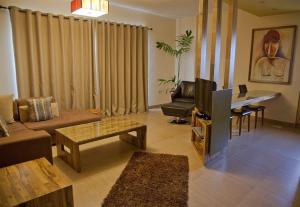 sala de estar con sofá y TV en Roots Apartment Hotel, en Accra