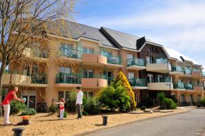 a family playing frisbee in front of a building at Azureva Pornichet Baie de La Baule in Pornichet