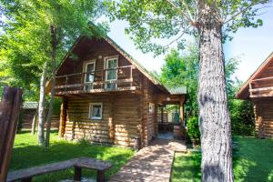 a log cabin with a porch and a tree at Chastnaya Dacha in Volgograd