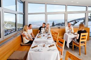 
people sitting at a table in a restaurant at Horsky Hotel Sliezsky Dom in Vysoké Tatry
