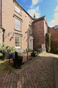 ein Backsteinhaus mit einem Zaun davor in der Unterkunft The Library House B&B in Ironbridge