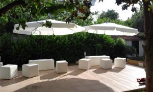 a group of white chairs and umbrellas on a patio at Villa Del Mar in Bari +11 photos