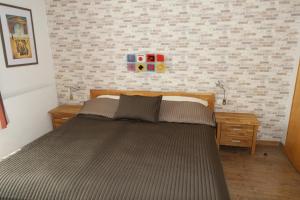 a large bed in a bedroom with a brick wall at Appartement Gwiggner in Niederau