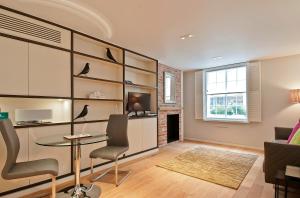 ein Wohnzimmer mit einem Tisch und Stühlen in der Unterkunft Wigmore Suites Serviced Apartments by Globe Apartments in London