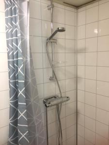 La salle de bains est pourvue d'une douche et de carrelage blanc. dans l'établissement Enångers Bed and Breakfast, à Enånger