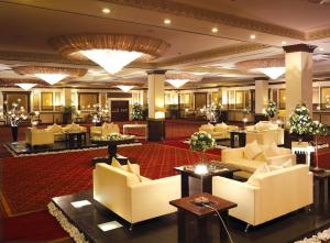 a hotel lobby with white couches and tables at Pearl Continental Hotel, Karachi in Karachi