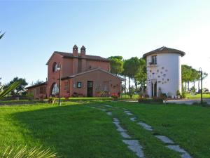a house with a grassy yard in front of a building at Poggio Verde in Castiglione del Lago