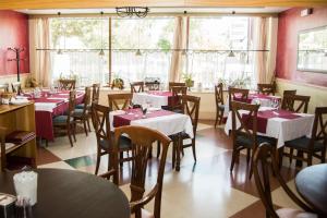 a dining room with tables and chairs and windows at Hotel Nobis Salamanca in Salamanca