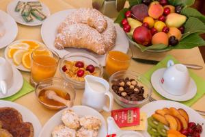 ヴィエステにあるVilla Fenice Bed & Breakfastの朝食用の食材とフルーツを盛り付けたテーブル