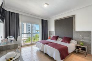 ein Schlafzimmer mit einem großen Bett und einem großen Fenster in der Unterkunft Hotel Vibra Marco Polo I - Adults only in Sant Antoni de Portmany
