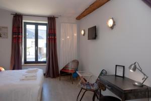 um quarto com uma cama, uma secretária e uma janela em Les Tournelles - Chambres d'hôtes em Saint-Mesmes
