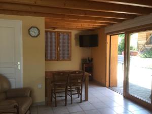 - un salon avec une table, des chaises et une horloge dans l'établissement Auberge La Ferme De Ferrières, à Pringy