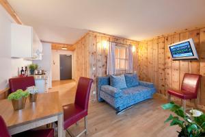 a living room with a blue couch and a table at Martinshof in Sankt Johann in Tirol