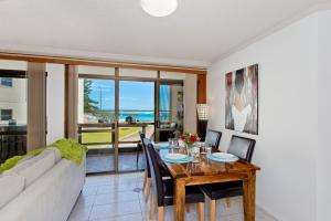 - un salon avec une table et un canapé dans l'établissement Beauty at the Beach - modern beachfront apartment, à Port Macquarie