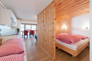zwei Betten in einem Zimmer mit Holzwand in der Unterkunft Martinshof in Sankt Johann in Tirol + 31 Fotos