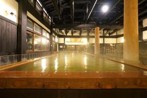 un gimnasio vacío con un gran salón con suelo de madera en Mikasa Tennen Onsen Taikonoyu Sparesort Hotel Taiko Bettei Hatago, en Iwamizawa