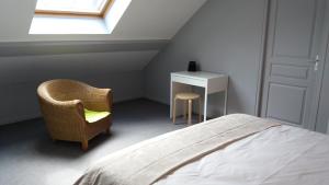 een slaapkamer met een bed, een stoel en een bureau bij Apt 8 du Temple HyperCentre & Parking in Cambrai