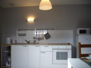 uma cozinha com armários brancos e um frigorífico branco em Apt 8 du Temple HyperCentre & Parking em Cambrai