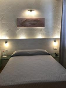 a bedroom with a large bed with a white headboard at NovaHotel in Reggio Emilia