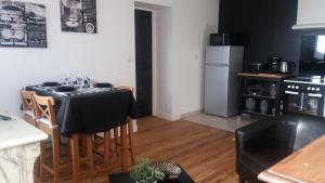 a kitchen with a table with a black table cloth at Apt 6 du Temple 2 chambres & Parking in Cambrai