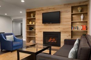 a living room with a fireplace and a tv on a wall at Hotel Flamingo Inn & Suites Vero Beach I-95 in Vero Beach