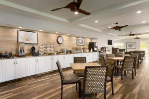 a restaurant with tables and chairs and a counter at Hotel Flamingo Inn & Suites Vero Beach I-95 in Vero Beach +9 photos