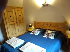 a bedroom with a blue bed with two pillows at Gîte du Charri in Le Tholy