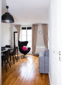 sala de estar con sofá y mesa en Apart By Jo, en Saint-Germain-en-Laye