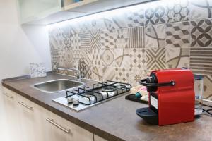 a kitchen counter with a red refrigerator next to a sink at B&B Regina ELENA in Campobasso