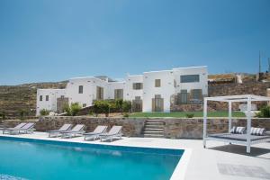 een villa met een zwembad en witte gebouwen bij Agiasi Villas in Lefkes