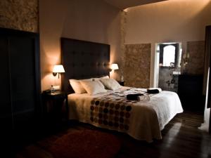- une chambre avec un lit avec une couverture blanche et 2 lampes dans l'établissement Casa Rural el Castillico, à Yecla