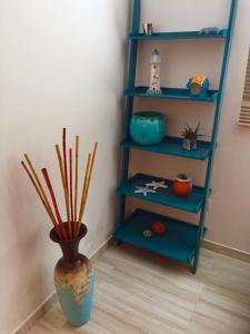 a blue shelving unit with a vase with sticks in it at Black see apartment in K'obulet'i