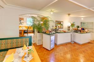 a kitchen with white cabinets and a table and chairs at Hotel Kleiner König in Schwangau