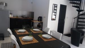 a dining room with a black table and white chairs at Loft 4 du Temple HyperCentre & Parking in Cambrai