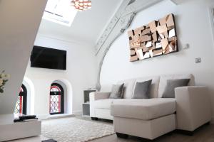 a living room with a white couch and a tv at The Chapel Chester - Boutique Apartments in Chester