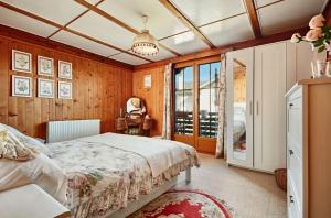 a bedroom with a bed in a room with wooden walls at Le Liseron in Leysin