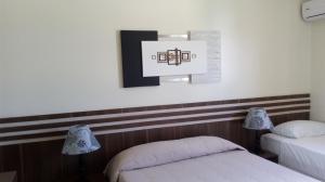 a room with two beds and a picture on the wall at Hotel Real Park in Jacareí