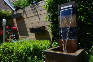 a water fountain in the middle of a garden at Hôtel Le Patio - Deauville in Deauville